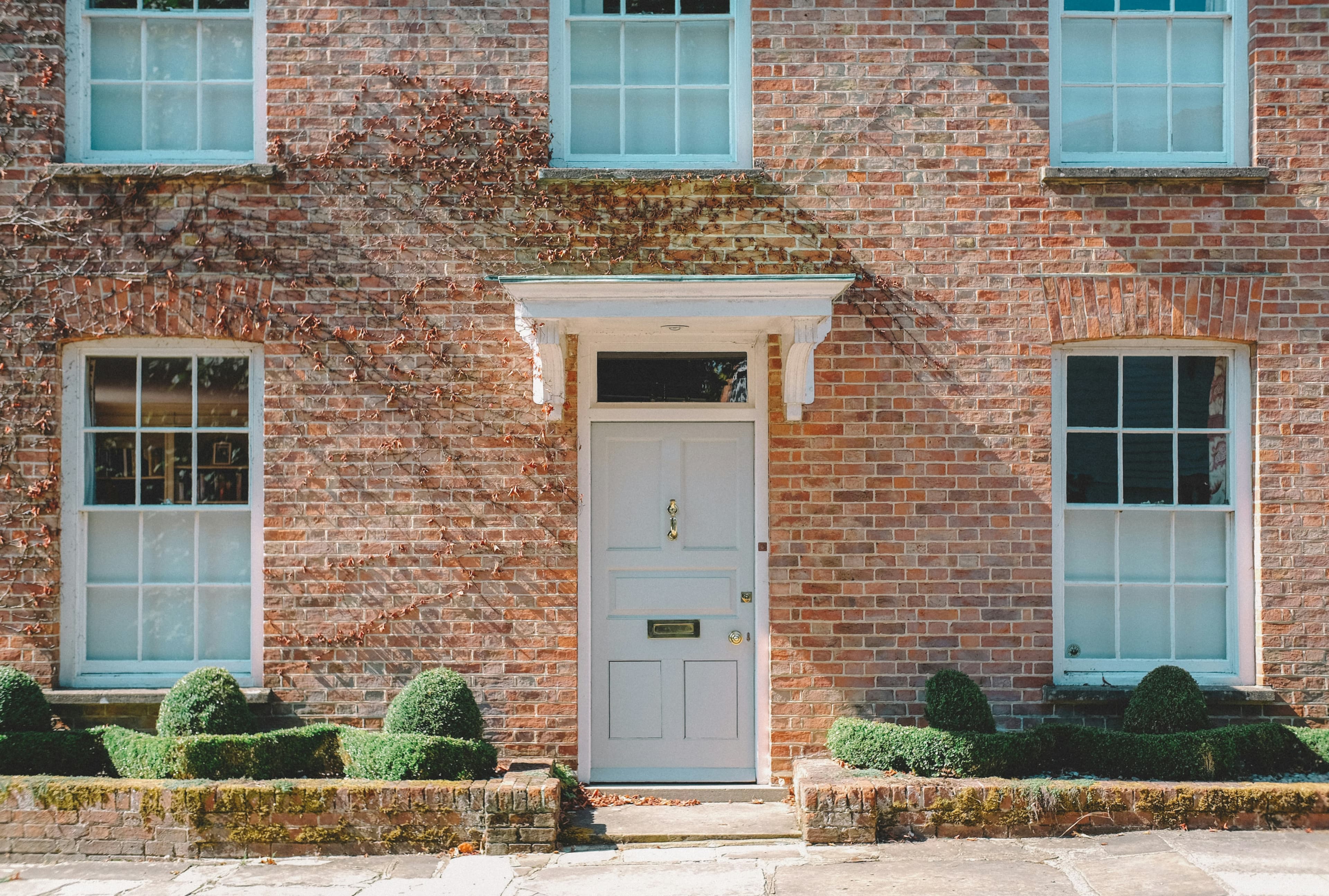 Brick terraced house with a white porch entrance and sash windows