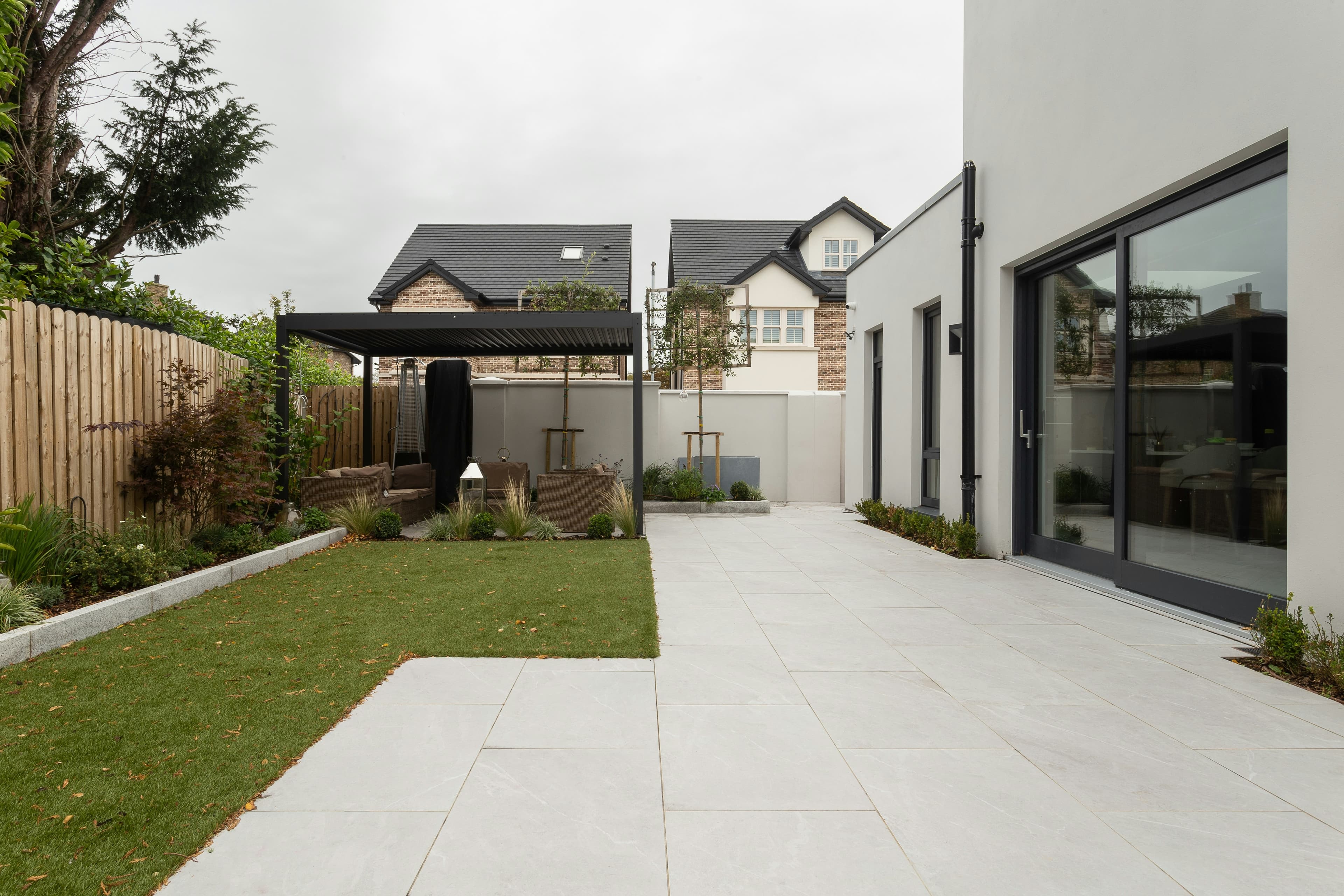 Contemporary rear extension with glazed sliding doors onto a paved garden